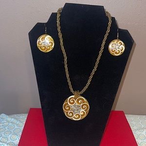 Gold beaded necklace with large pendant that has white spiral shell design